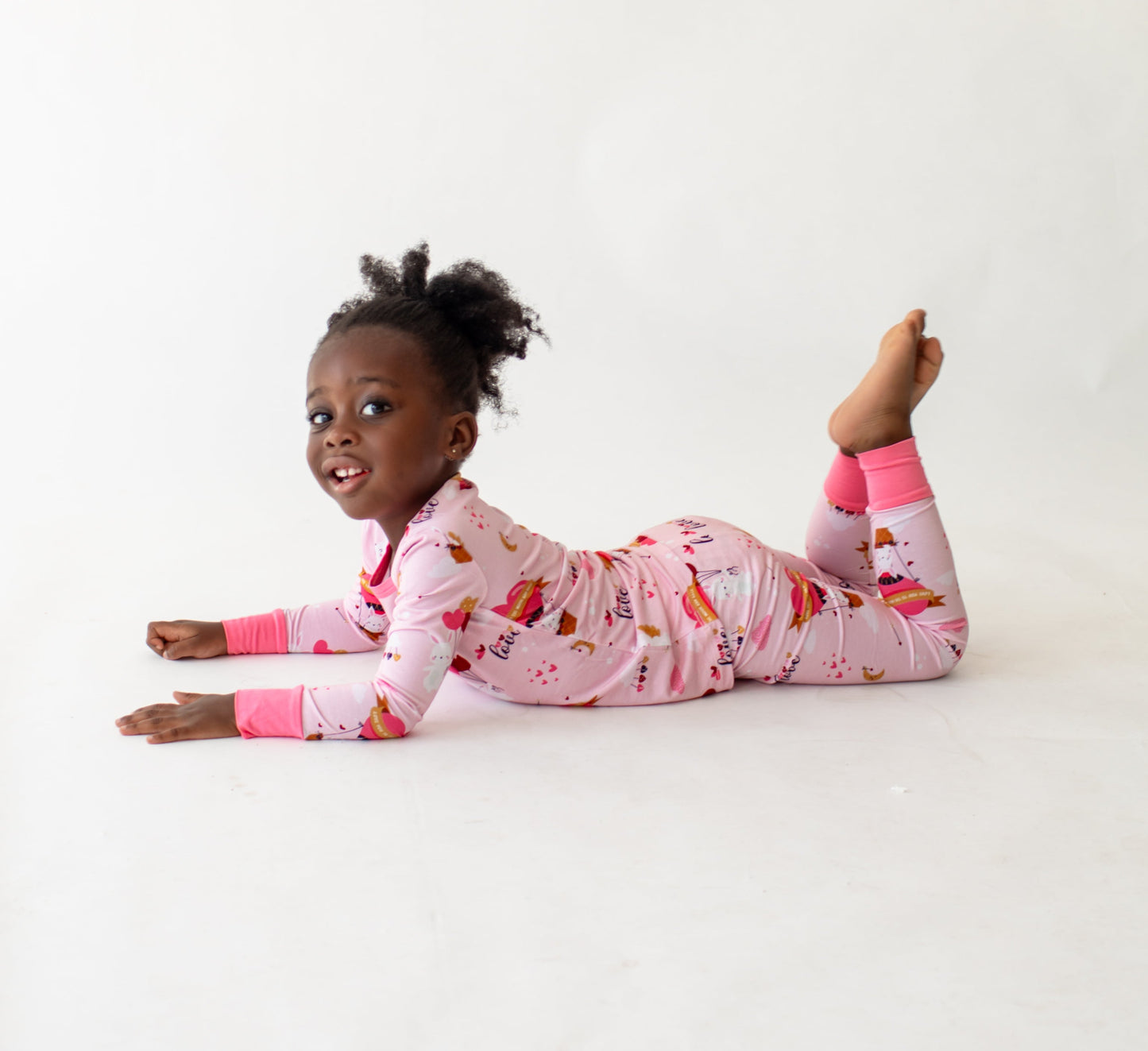 Child wearing Pink bamboo kids pajamas featuring Cupid the Bunny with braille label