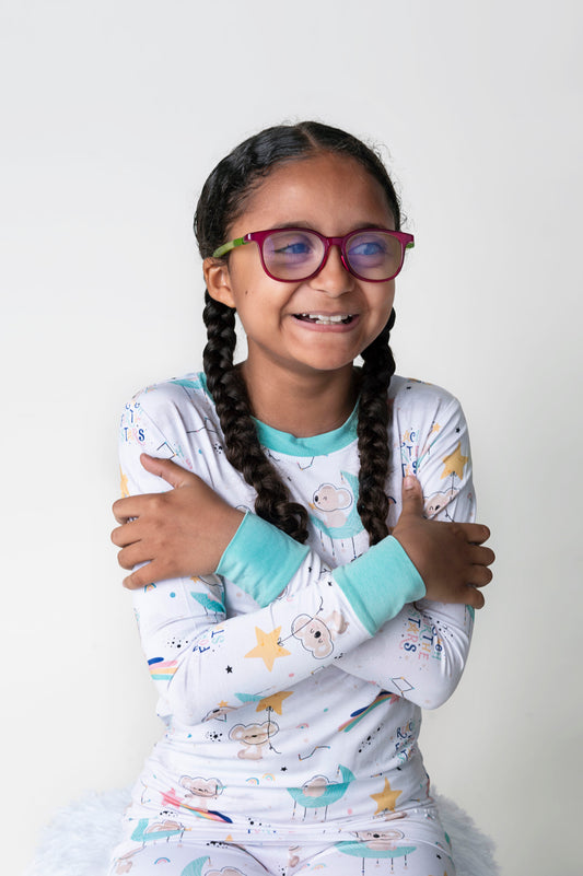 Child featured wearing soft white bamboo pajamas featuring Kenny the Koala in space