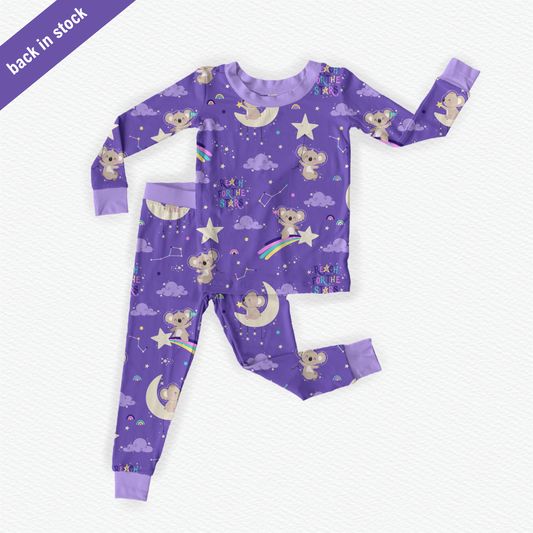 Purple bamboo kids pajamas featuring Kenny the Koala with braille label