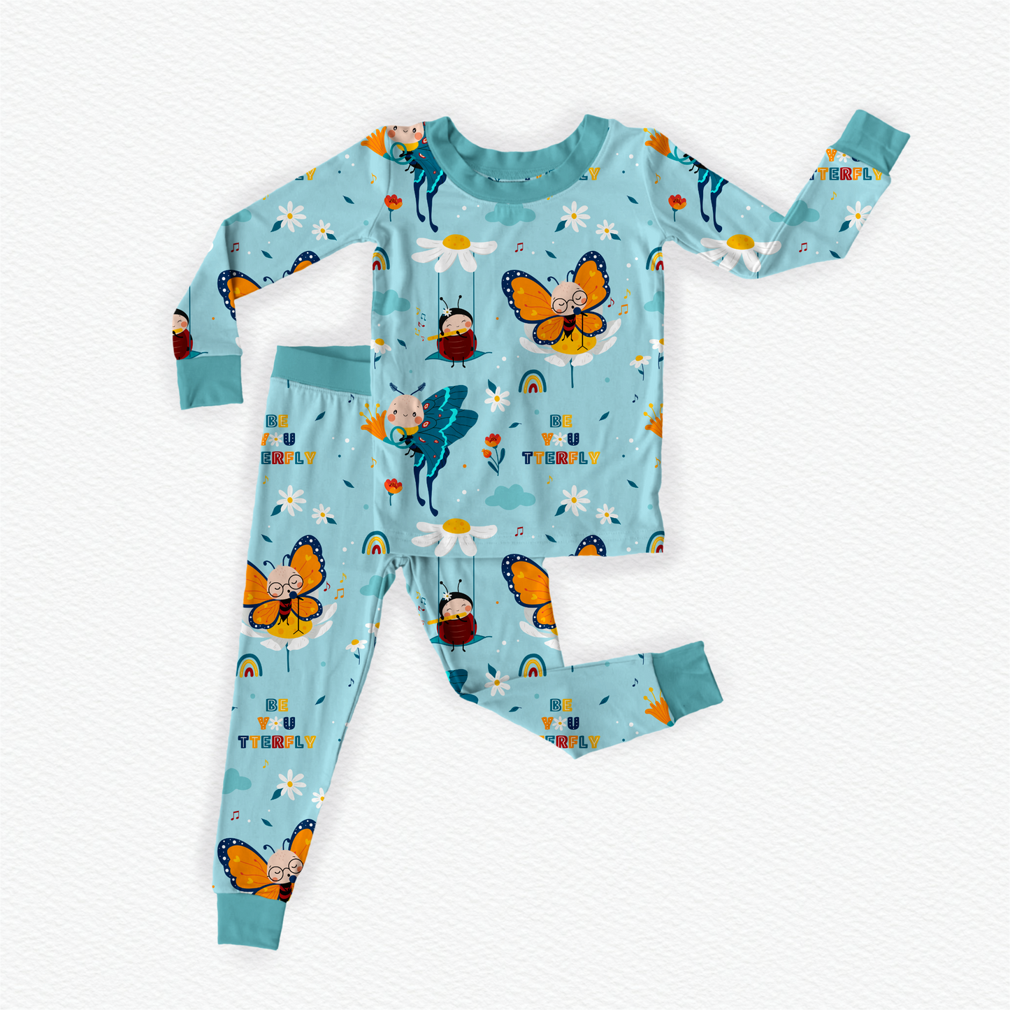 Flat lay of baby blue bamboo kids pajamas featuring a butterfly and other small designs, 