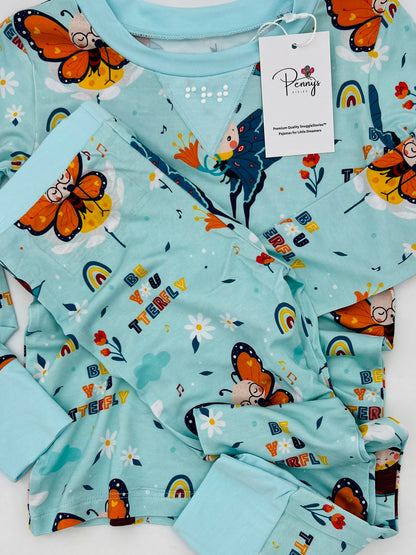 Close up of pattern on Blue bamboo kids pajamas featuring Bodhi the Butterfly with braille label